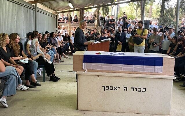 Nissim Louk eulogizes his daughter Shani at the cemetery of Moshav Srigim-LiOn in central Israel as the family (left) looks on, May 19, 2024. (Sue Surkes/Times of Israel) Nissim Louk eulogizes his daughter Shani at the cemetery of Moshav Srigim-LiOn in central Israel as the family (left) looks on, May 19, 2024. (Sue Surkes/Times of Israel)