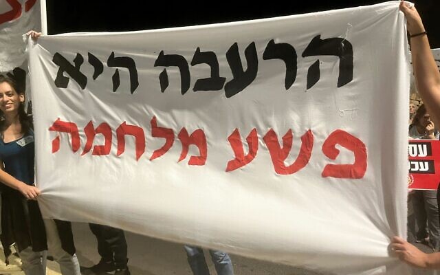 Protesters hold a banner reading "starvation is a war crime" outside the Knesset, in Jerusalem, May 18, 2024. (Leon Kraiem/The Times of Israel) Protesters hold a banner reading "starvation is a war crime" outside the Knesset, in Jerusalem, May 18, 2024. (Leon Kraiem/The Times of Israel)