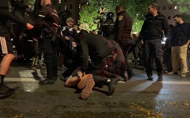A group of police officers arrest an anti-government protester at Jerusalem's Paris Square on May 4, 2024. (Charlie Summers/Times of Israel) A group of police officers arrest an anti-government protester at Jerusalem's Paris Square on May 4, 2024. (Charlie Summers/Times of Israel)