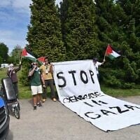 Protesters wave Palestinian flags and claim a genocide is unfolding in Gaza outside the Auschwitz extermination camp in Poland on May 6,  2024. (Canaan Lidor/Times of Israel)