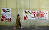 A student from the Public University of Navarra passes next to banners in Basque and Spanish supporting Palestinians and calling to "combat, denormalize and destroy Israel," in Pamplona, northern Spain, on Wednesday, April 8, 2024. (AP/Alvaro Barrientos)