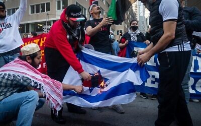 Protesters burn an Israeli flag at a demonstration led by Within Our Lifetime in Manhattan, May 14, 2021. (Luke Tress)