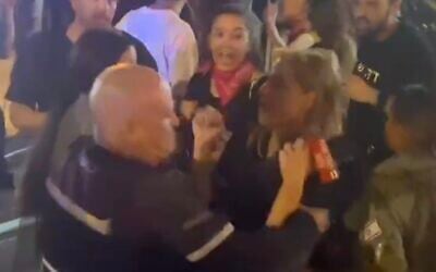 A screenshot of video showing a police officer grabbing Channel 12 news reporter Yollan Cohen at an anti-government protest in Tel Aviv, June 22, 2024. (Screenshot: X, used in accordance with Clause 27a of the Copyright Law)