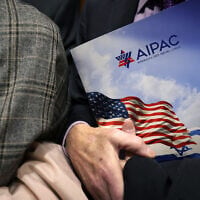 Illustrative: A visitor to the US Capitol, wearing a yellow ribbon to raise awareness for hostages held by Hamas in Gaza, clutches an AIPAC folder while taking the elevator in the Rayburn House Office Building, in Washington, DC, March 12, 2024. (Alex Wong / Getty Images North America / Getty Images via AFP)