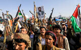 Yemenis brandish rifles and wave Palestinian flags during a march in the Houthi-run capital Sanaa in solidarity with Gazans on May 31, 2024. (Mohammed Huwais/AFP)