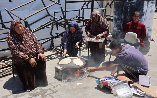 Palestinians light a fire to cook bread at a UN school housing displaced people in Gaza City on June 4, 2024. (Omar Al-Qataa/AFP) Palestinians light a fire to cook bread at a UN school housing displaced people in Gaza City on June 4, 2024. (Omar Al-Qataa/AFP)