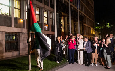 People hang a Palestinian flag in front of the parliament building after Slovenia's national assembly voted to recognize Palestinian state, in Ljubljana, on June 4, 2024. (AFP)