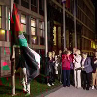 People hang a Palestinian flag in front of the Slovenian Parliament building after the National Assembly recognized a Palestinian state in Ljubljana, on June 4, 2024. (AFP)