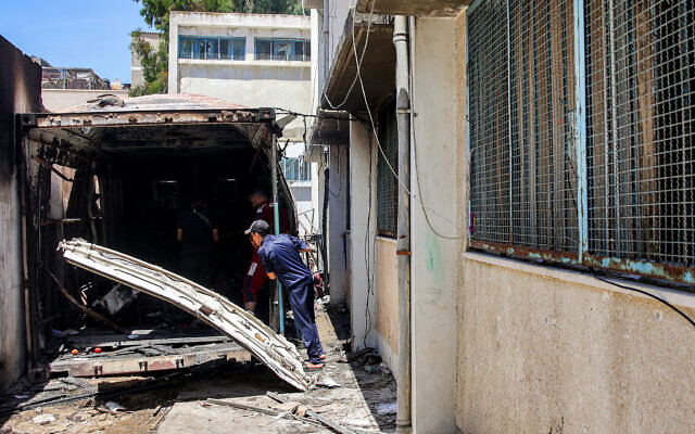 Youths inspect damage to a storage container that was hit by an Israeli strike at the Asmaa school, run by the UN Relief and Works Agency for Palestine Refugees (UNRWA), in Gaza City's Shati refugee camp, June 7, 2024. The IDF says a Hamas cell was operating from the container. (Omar Al-Qattaa / AFP)