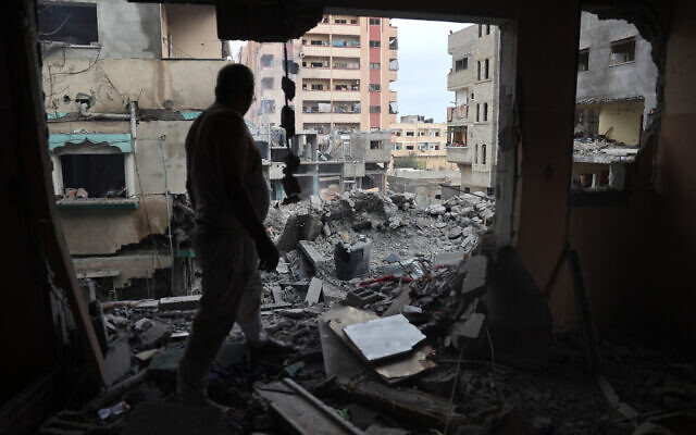 A Palestinian man inspects damage a day after a hostage rescue operation by Israel in the Nuseirat camp, in the central Gaza Strip on June 9, 2024. (Eyad Baba/AFP)