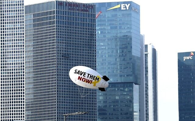 A small airship calling for their release of hostages held in Gaza flies over Tel Aviv on June 9, 2024. (JACK GUEZ / AFP)