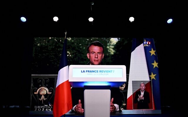 A screen broadcasts an address to the nation by France's President Emmanuel Macron calling for new general elections on June 30 during an evening gathering of French far-right party Rassemblement National (RN) on the final day of the European Parliament election, at the Pavillon Chesnaie du Roy in Paris, on June 9, 2024. (JULIEN DE ROSA / AFP)