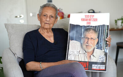 Former hostage Tami Metzger poses for a picture with a portrait of her husband Yoram, who was declared dead in captivity on June 3, during an interview at her residence in the southern city of Kiryat Gat on June 9, 2024. (Sharon ARONOWICZ / AFP)