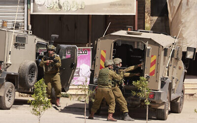 Illustrative: Israeli forces take a position in a street during a raid in the al-Faraa camp, near Tubas in the West Bank on June 10, 2024. (Jaafar Ashtiyeh/AFP)