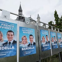 Electoral posters of National Rally (Rassemblement National) party with the pictures of Marine Le Pen (L) and Jordan Bardella are seen pasted on in Henin-Beaumont on June 10, 2024, a day after the European elections. (Denis Charlet/AFP)