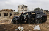 A Palestinian man inspects the carcass of a car shot at by Israeli forces during a raid in which four Palestinians, including a Hamas commander and a member of the terror group, were killed in Kafr Ni'ma in the West Bank on June 11, 2024. (Zain JAAFAR / AFP)