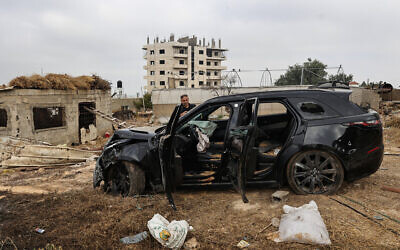 A Palestinian man inspects the carcass of a car shot at by Israeli forces during a raid in which four Palestinians, including a Hamas commander and a member of the terror group, were killed in Kafr Ni'ma in the West Bank on June 11, 2024. (Zain JAAFAR / AFP)