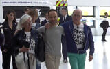 French citizen Louis Arnaud, who was imprisoned in Iran, flanked by his mother and father upon arrival at Le Bourget Airport, north of Paris, on June 13, 2024. (LCI/POOL/AFP)