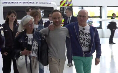 French citizen Louis Arnaud, who was imprisoned in Iran, flanked by his mother and father upon arrival at Le Bourget Airport, north of Paris, on June 13, 2024. (LCI/POOL/AFP)