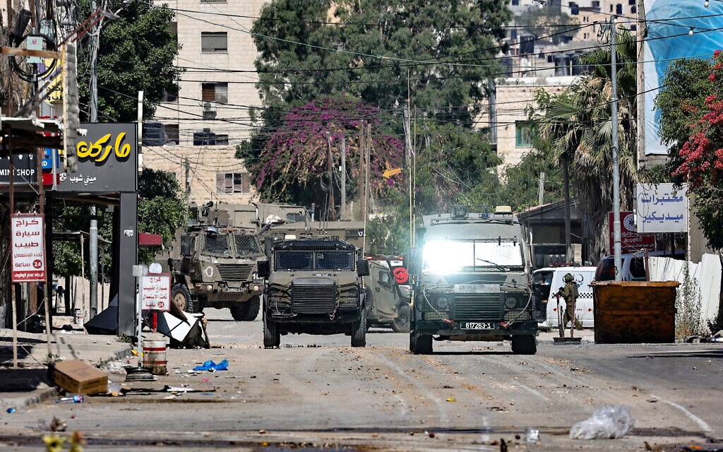 Israeli army vehicles take a position at the entrance of Jenin in the West Bank, during a raid on June 13, 2024. (Photo by Zain JAAFAR / AFP)