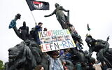 Demonstrators stand next to and on the statue The Triumph of the Republic on Place de la Nation as they take part in an anti far-right rally in Paris on June 15, 2024 (Sameer Al-Doumy / AFP)