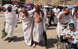 A man affected by the scorching heat is helped by another as Muslim pilgrims arrive to perform the symbolic 'stoning of the devil' ritual as part of the hajj pilgrimage in Mina, near Saudi Arabia's holy city of Mecca, on June 16, 2024. (Fadel Senna/AFP)