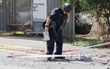 An Israeli police officer inspects a site where rockets launched from southern Lebanon struck in Kiryat Shmona in northern Israel, on June 19, 2024. (Jalaa MAREY / AFP)