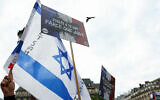 Illustrative: Protesters wave an Israeli flag and hold a placard reading 'Raped because she is Jewish' as they gather to condemn the alleged antisemetic gang rape of a 12-year-old girl, outside the Paris city hall, June 19, 2024. (Alain Jocard / AFP)