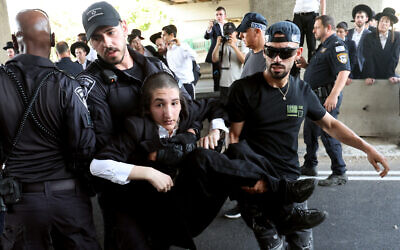 Police disperse ultra-Orthodox Jews blocking a highway during a protest against the military draft, in the central city of Bnei Brak, on June 20, 2024. (Jack Guez/AFP)