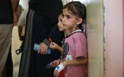 Illustrative: Palestinian children wait with family members at Nasser hospital in Khan Younis in the southern Gaza Strip on June 24, 2024. (Bashar TALEB / AFP)