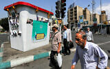 People walk past an installation depicting a replica of a ballot box along a street in Tehran on June 26, 2024. (Raheb Homavandi / AFP)