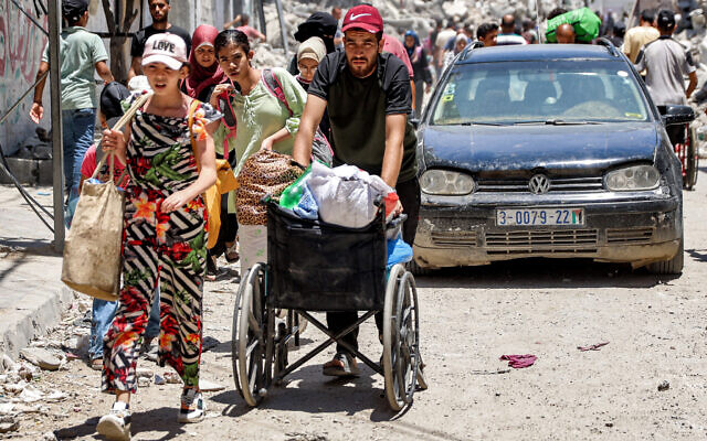 A man pushes a wheelchair loaded with items while evacuating with others from the Tuffah neighbourhood in the east of Gaza City on June 27, 2024 (Omar Al-Qattaa/AFP) A man pushes a wheelchair loaded with items while evacuating with others from the Tuffah neighbourhood in the east of Gaza City on June 27, 2024 (Omar Al-Qattaa/AFP)