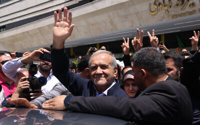 Iranian presidential candidate and reformist Massoud Pezeshkian reacts to the crowd outside a polling station where he cast his vote in the presidential election in Tehran on June 28, 2024. (ATTA KENARE / AFP)