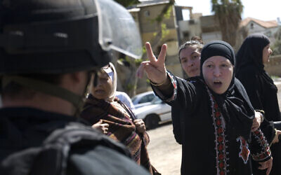 An Israeli Arab woman gestures as she faces an Israeli riot police officer during a march of right wing activists in the streets of Jaffa, a mixed Jewish and Arab neighborhood in Tel Aviv, Israel, Wednesday, March 2, 2011. (AP/Ariel Schalit)