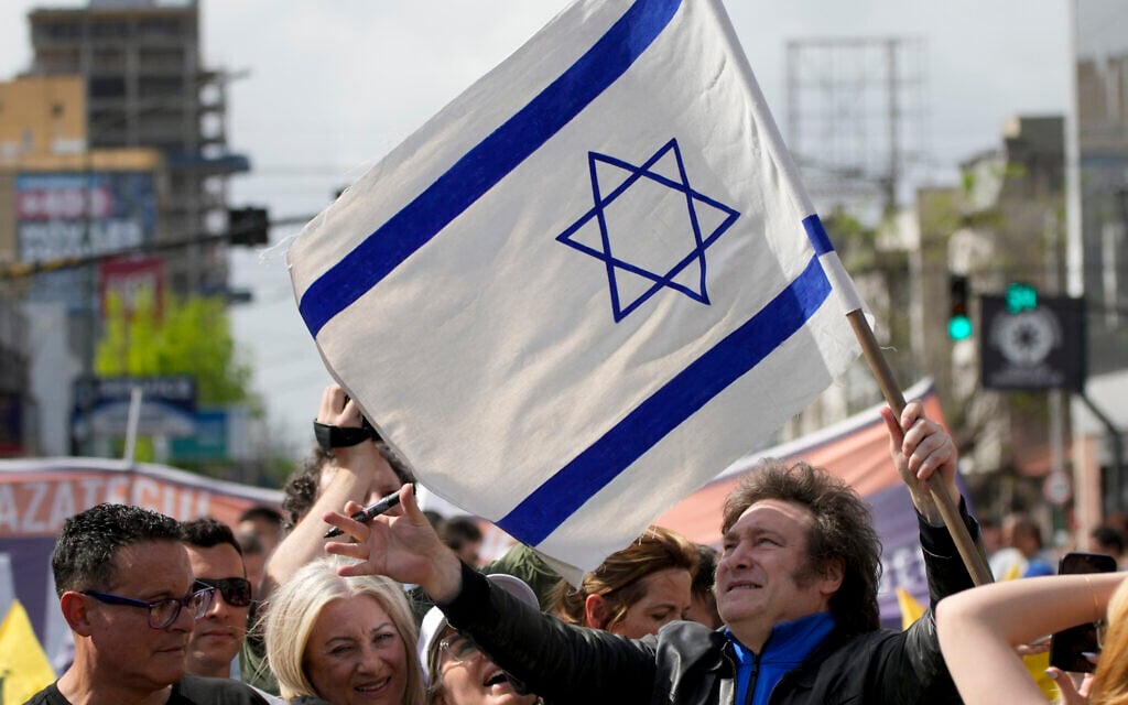 Then-presidential hopeful Javier Milei holds an Israeli flag during his campaign rally in Lomas de Zamora, Argentina, October 16, 2023. (Natacha Pisarenko/AP) Then-presidential hopeful Javier Milei holds an Israeli flag during his campaign rally in Lomas de Zamora, Argentina, October 16, 2023. (Natacha Pisarenko/AP)