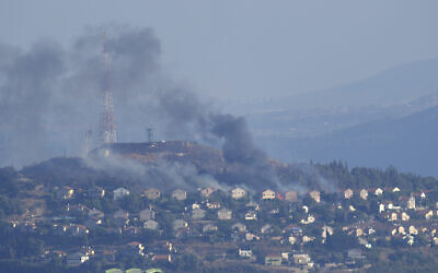 Black smoke rises from homes in the northern Israeli border community of Metula after being hit by Hezbollah anti-tank missiles, as seen from the Lebanese town of Marjayoun, June 22, 2024. (AP/Hussein Malla)