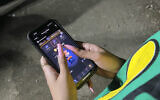 A woman plays Hamster Combat game on a cell phone in Tehran, Iran, June 23, 2024 (AP Photo/Vahid Salemi)