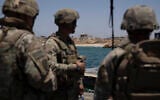 US Army soldiers stand at the US-built floating pier Trident backdropped by the coast of the Gaza Strip, June 25, 2024. (AP/Leo Correa)