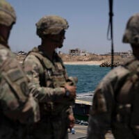 US Army soldiers stand at the US-built floating pier Trident backdropped by the coast of the Gaza Strip, June 25, 2024. (AP/Leo Correa)