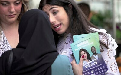 Shannon Seban, a legislative election candidate for the camp of President Emmanuel Macron, campaigns, in the Paris suburb of Ivry-sur-Seine, Tuesday June 25, 2024. (AP Photo/John Leicester)