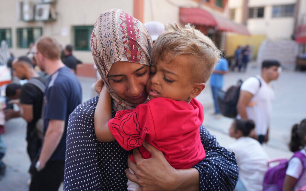 A Palestinian woman says goodbye to her sick son before leaving the Gaza Strip to get treatment abroad through the Kerem Shalom crossing, in Khan Younis, southern Gaza Strip, Thursday, June 27, 2024. (AP Photo/Abdel Kareem Hana)