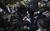 Police officers disperse ultra-Orthodox Jews blocking a highway during a protest against army recruitment in Bnei Brak, Israel, Thursday, June 27, 2024. (AP/Oded Balilty)