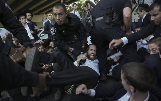 Police officers disperse ultra-Orthodox Jews blocking a highway during a protest against army recruitment in Bnei Brak, Israel, Thursday, June 27, 2024. (AP/Oded Balilty) Police officers disperse ultra-Orthodox Jews blocking a highway during a protest against army recruitment in Bnei Brak, Israel, Thursday, June 27, 2024. (AP/Oded Balilty)