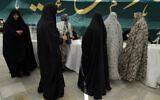 Women get their ballot paper during the Iranian presidential election in a polling station at the shrine of Saint Saleh in northern Tehran, June 28, 2024. (AP/Vahid Salemi)