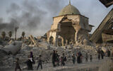 Fleeing Iraqi civilians pass the heavily damaged al-Nuri mosque as Iraqi forces continue their advance against the Islamic State in the Old City of Mosul, July 4, 2017. (AP/Felipe Dana)