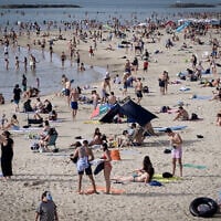 Illustrative: Israelis enjoy the beach in Tel Aviv during a heatwave, on April 24, 2024. (Avshalom Sassoni/Flash90)