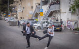 A secular man and an ultra-Orthodox man fight during a protest against the drafting of Haredi Jews to the military, outside the IDF army recruitment office in Jerusalem, May 1, 2024. (Chaim Goldberg/Flash90)