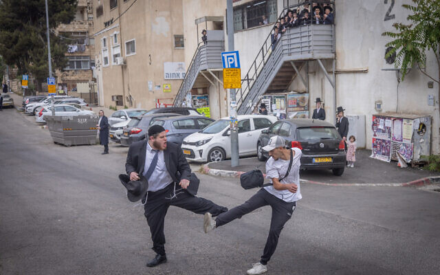 A secular man and an ultra-Orthodox man fight during a protest against the drafting of Haredi Jews to the military, outside the IDF army recruitment office in Jerusalem, May 1, 2024. (Chaim Goldberg/Flash90) A secular man and an ultra-Orthodox man fight during a protest against the drafting of Haredi Jews to the military, outside the IDF army recruitment office in Jerusalem, May 1, 2024. (Chaim Goldberg/Flash90)