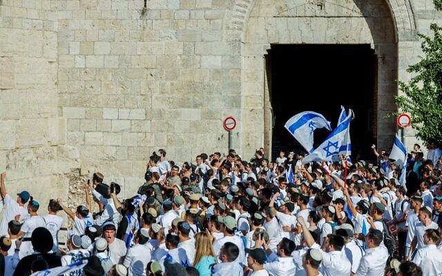 Men hold Israeli flags as they dance at Damascus Gate in Jerusalem's Old City, during the Jerusalem Day flag march, June 5, 2024. (Chaim Goldberg/Flash90) Men hold Israeli flags as they dance at Damascus Gate in Jerusalem's Old City, during the Jerusalem Day flag march, June 5, 2024. (Chaim Goldberg/Flash90)