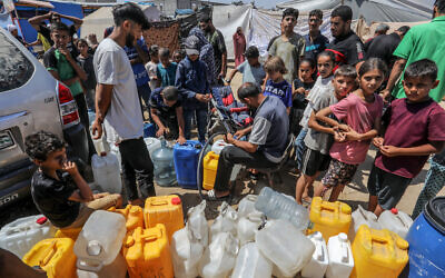 Palestinians line up to obtain drinking water during its distribution in the tents of the displaced, in Deir al-Balah in the central Gaza Strip, on June 10, 2024. (Abed Rahim Khatib/Flash90)
